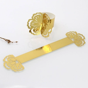 Detailed view of laser-cut gold floral paper napkin rings showing flat and folded forms