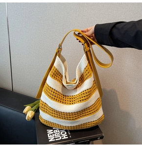 Detail of yellow and white striped knit tote bag with adjustable leather shoulder strap