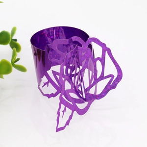 Detail of purple glitter laser-cut rose napkin ring with intricate hollowed patterns