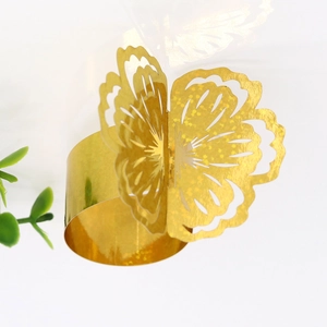Detail of golden glitter butterfly napkin ring with laser cut hollow wings on white