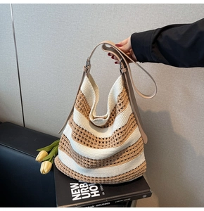 Detail of hollow woven tote bag with beige and brown stripes and adjustable leather strap