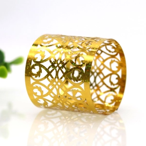 Close-up of golden hollow napkin ring with intricate European scroll pattern and glitter