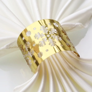 Detailed macro view of a gold snowflake napkin ring with intricate cutout patterns