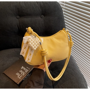 Dettaglio borsa a mezzaluna in pelle martellata giallo limone con cuore di perle