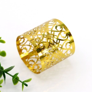 Detailed view of golden laser-cut napkin ring with intricate floral lace patterns