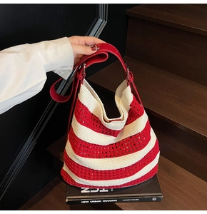 Detail of red and white woven tote bag featuring hollow knit texture and leather strap