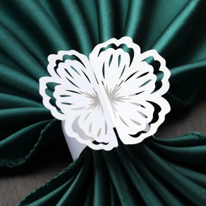 Macro detail of white laser-cut butterfly paper napkin ring with pearl glitter finish