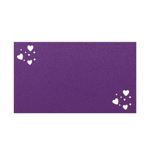 Detail of purple place card featuring elegant laser-cut heart patterns and textured paper