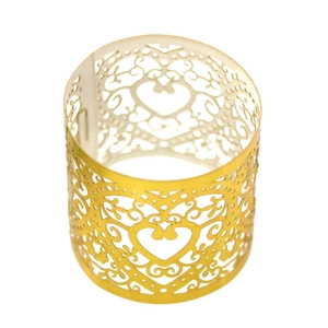 Close-up of golden hollow heart napkin ring with laser-cut filigree patterns