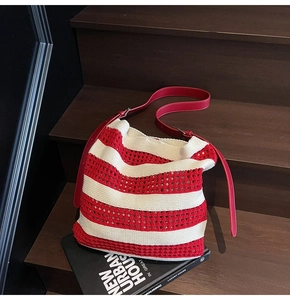 Detail of red and cream knit tote bag with woven texture and adjustable leather strap