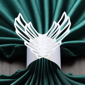 Detailed macro view of white laser-cut angel wing paper napkin ring with pearl finish