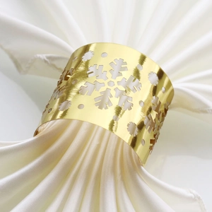 Close-up of golden metal snowflake napkin ring with intricate hollow engraving
