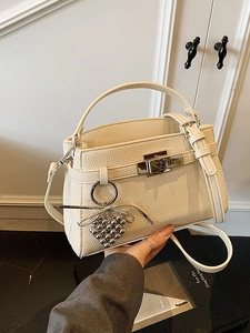 Chic cream-colored lychee textured leather Kelly style handbag with metal clasp and strap