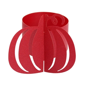 Detail showing the intricate laser-cut red pumpkin paper napkin ring for Halloween table decor
