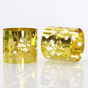 Macro shot of gold snowflake napkin rings featuring intricate cutout patterns and mirror finish