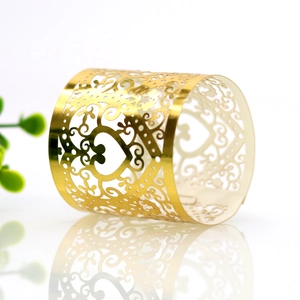 Macro detail of laser-cut heart pattern napkin ring with golden metallic finish