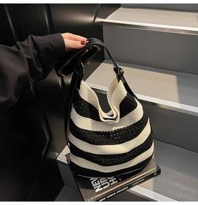 Close-up of black and white woven tote bag with sequins on modern urban book
