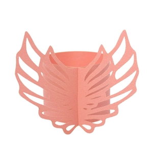 Detail of pink laser-cut paper angel wings napkin ring with delicate wing patterns