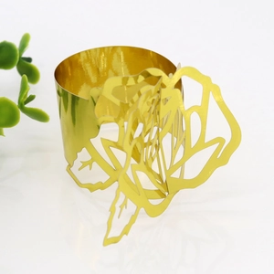 Macro shot of a gold-plated rose napkin ring featuring intricate floral cutout details