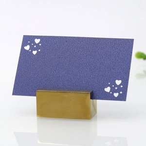 Golden heart-shaped place card holder with a textured purple card for wedding table decor