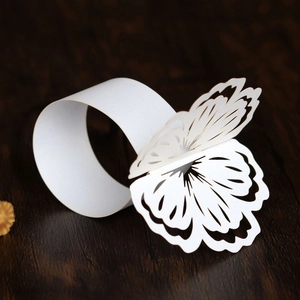 Detailed macro view of a laser-cut 3D butterfly napkin ring on a wooden surface
