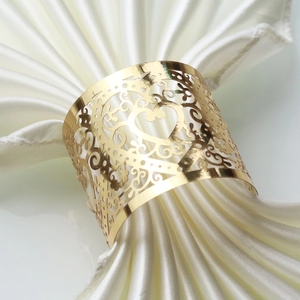 Elegant gold hollow napkin ring with laser-cut filigree pattern for wedding decor
