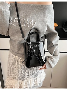 Chic black patent leather bucket bag with white logo and heart pendant for women