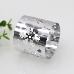 Close-up of shiny silver snowflake napkin ring with intricate hollow metal design