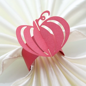 Close-up of red hollow pumpkin paper napkin ring with intricate laser-cut texture