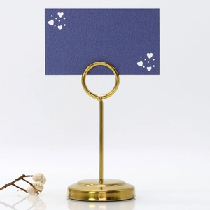 Detailed view of a gold heart-shaped place card holder with a navy blue name tag