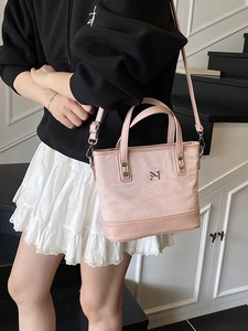 Pink canvas bucket bag with leather handles and silver logo for fashion styling
