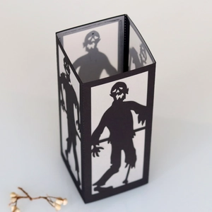 Detail of laser-cut zombie silhouette on a black Halloween paper lantern lampshade