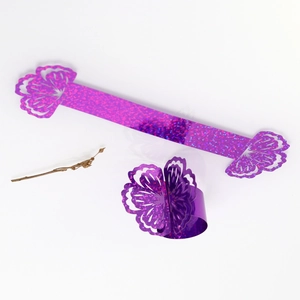 Detail showing purple glitter paper napkin ring with intricate laser-cut floral patterns