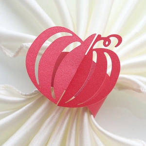 Close-up of laser-cut red pumpkin paper napkin rings for Halloween table decor
