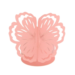 Detail of pink laser-cut butterfly napkin ring with intricate floral hollow pattern