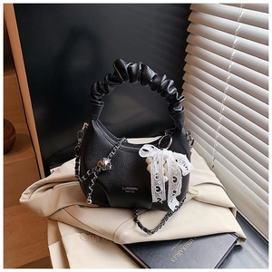Detail of black crescent handbag with pleated cloud handle and pearl lace bow accessory