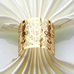 Detail view of heart shaped gold metal napkin ring with elegant floral cutouts