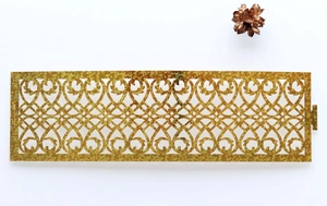 Detailed macro view of laser-cut golden napkin ring with sparkling heart vine patterns