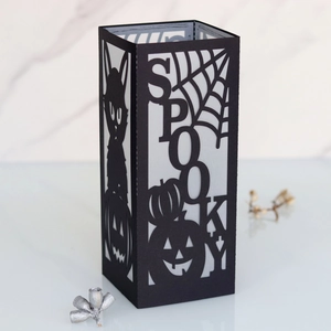 Detail of black laser-cut Halloween lantern with spooky text and spider web patterns