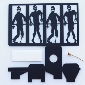 Detail of Halloween DIY black paper lantern kit featuring zombie silhouettes and cutouts