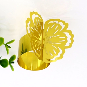 Macro detail of golden butterfly napkin ring with intricate laser-cut wing patterns