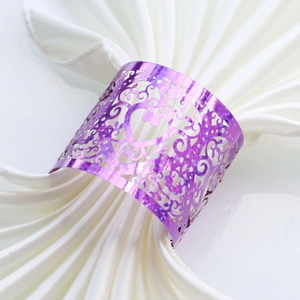 Detail of purple laser-cut heart napkin ring with elegant scrollwork on white silk