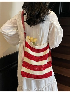 Stylish red and white striped woven tote bag with leather strap on a female model