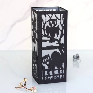 Detailed laser-cut Halloween paper lantern featuring black witch and pumpkin silhouettes