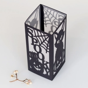 Macro shot of Halloween paper lantern with laser-cut spooky spider web and pumpkin design