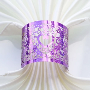 Detail of purple laser-cut heart napkin ring with glitter finish on white silk