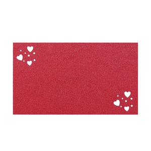 Macro detail of red glitter heart place card with laser-cut patterns for wedding table