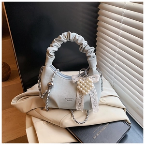 Detail of light blue grain leather handbag with pleated handle and chain strap