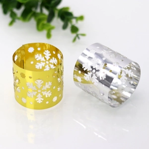 Detailed close-up of hollow snowflake paper napkin rings in mirror gold and silver finishes