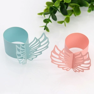 Detail of laser-cut pearlescent paper napkin rings with elegant angel wing design
